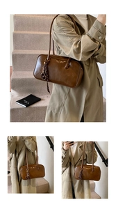 Gros plan d'un sac porté épaule vintage en cuir ciré marron avec breloque anneau tressé