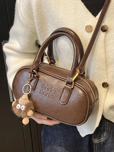 Sac bandoulière rétro marron en cuir avec breloque en peluche et logo embossé