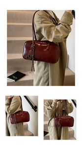 Gros plan du sac Boston vintage en cuir ciré rouge foncé avec breloque cœur métallique