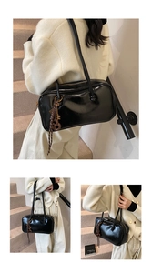 Détail du sac Boston en cuir ciré noir brillant avec pendentif à nœud marron