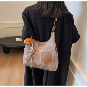 Dettaglio della borsa shopper grigia marmorizzata con rifiniture in pelle marrone
