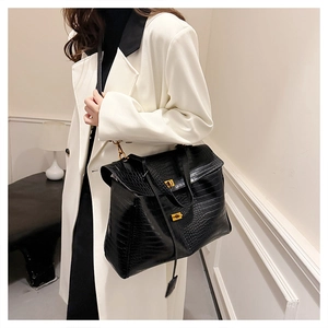 Close-up of black crocodile pattern leather tote bag with elegant gold dual locks