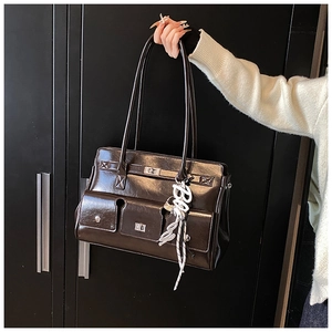 Detail of vintage leather messenger bag featuring multiple pockets and metal twist lock
