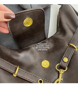 Close-up of the invisible magnetic closure and gold hardware on a dark brown leather bag