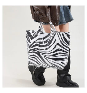 Close-up of zebra pattern tote bag in glossy material with white TOTE BAG text print