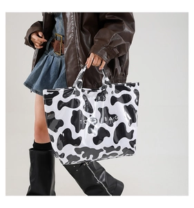 Detailed view of the large capacity tote bag with trendy cow print and TOTE BAG text