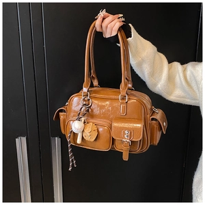 Detailed view of a brown bowling bag with multi-pockets and baseball charm detail