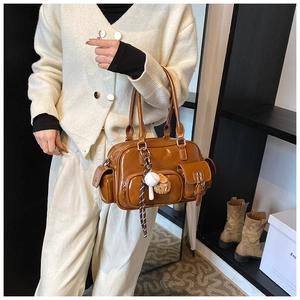 Close-up of brown PU bowling bag featuring multiple pockets and creative baseball charms