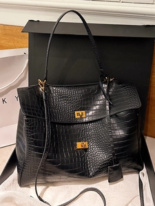 Elegant black crocodile-embossed tote bag with gold hardware and dual-handle design