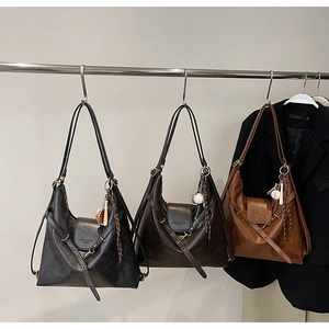 Detailed close-up of large tote bags in black, dark coffee and caramel with baseball charms