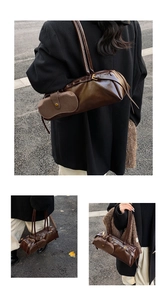 Detail of dark brown wax leather baguette bag with gold hardware and side pouch