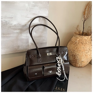 Detail of dark brown vintage messenger bag with glossy finish and front flap pockets