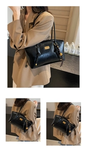Close-up of black oil wax leather handbag with golden logo and woven charm detail