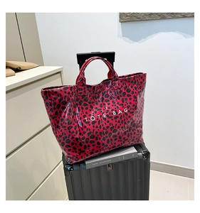 Macro shot of a red leopard print tote bag in glossy material with TOTE BAG text detail