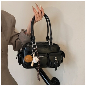 Detail of glossy black bowling bag featuring multiple pockets and baseball charms