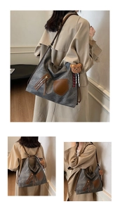 Macro detail of a vintage grey canvas tote bag with brown leather straps and a bear pendant
