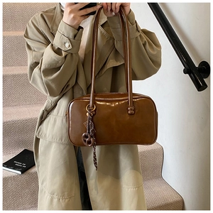 Vue détaillée du sac à bandoulière en cuir ciré vintage avec pendentif nœud chic