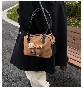 Retro caramel brown suede bowling bag with cute bread embroidery shown as a shoulder bag