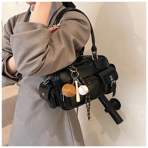 Detail of black glossy PU leather bowling bag with baseball keychain and multiple pockets