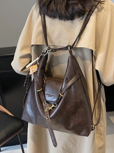 Brown vintage leather backpack for women with adjustable straps and decorative charms