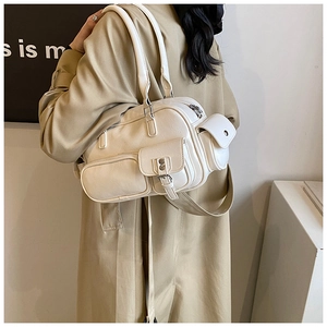 Detail view of cream white minimalist bowling bag with multi-pockets and metal buckles