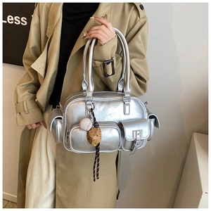 Detailed view of silver metallic bowling bag featuring utility pockets and baseball charm
