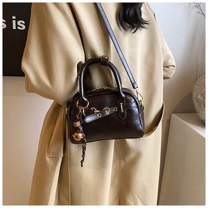Detail of dark brown vintage Boston bag with gold hardware and removable charm