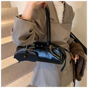 Detail of glossy oil wax leather shoulder bag with side mini pouch and metallic buckles