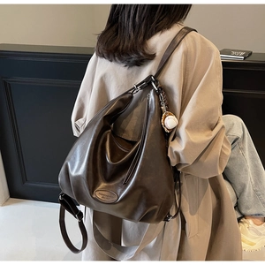 Dettaglio della borsa Hobo marrone scuro in morbida ecopelle con logo di moda