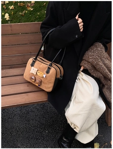 Detail of vintage brown suede tote bag with cute 3D plush bear and biscuit appliques