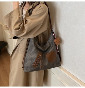 Detail of dark grey retro hobo bag with teddy charm and red checkered scarf decor