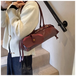 Close-up of deep red glossy oil wax leather bag with detachable glasses case charm