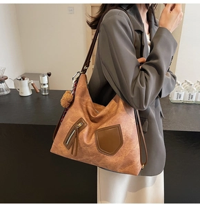 Retro brown hobo tote bag detail with floral silk scarf and fuzzy ball pendant decor
