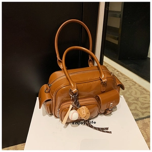 Close-up of brown glossy bowling bag with multi-pockets and baseball keychain charm