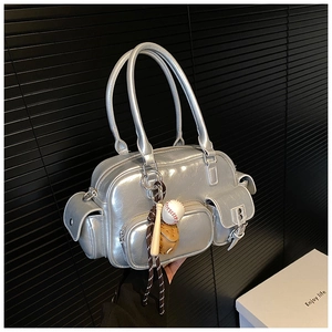 Detail of silver metallic handbag featuring multiple zip pockets and baseball charms