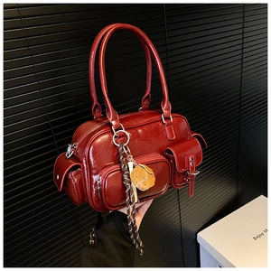Detailed macro view of dark red bowling bag showing glossy PU leather and side pockets