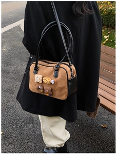 Detailed texture of brown suede shoulder bag with cute food-shaped cartoon patches