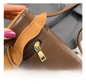 Close-up of golden metal zipper and brown leather texture on a cylindrical bag