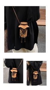 Detail of the unique cartoon doll shoulder bag with metal zipper and long leather strap