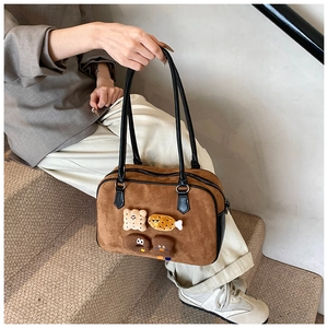 Detailed close-up of brown suede bag featuring cute 3D plush bear and donut patches