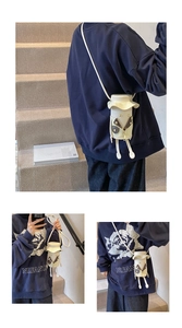 Detailed view of creative cream-white cartoon doll crossbody bag on a model