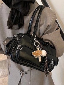 Glossy black PU bowling bag with vintage pockets and baseball charm on a female model