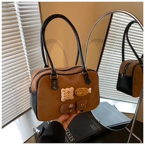 Detail of vintage brown suede and black leather patchwork bag with cartoon patches