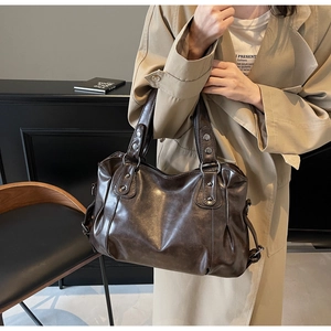 Détail du sac cabas en cuir marron foncé avec design plissé et rivets argentés vintage