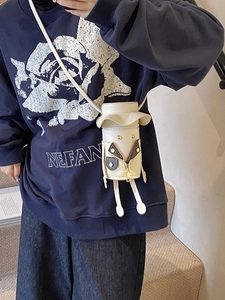 Quirky cartoon cylinder crossbody bag in cream white with 3D legs and zipper face detail