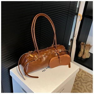 Detail view of a vintage brown leather baguette bag with a matching glasses case attachment