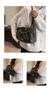 Close-up of black retro wrinkled underarm bag featuring MKMK leather logo and metal zipper