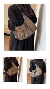 Detail of a pleated brown hobo shoulder bag with MKML logo and vintage PU leather texture