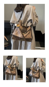 Detail view of vintage canvas tote with leather stitching, metal buckles and baseball charm