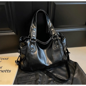 Détail du sac cabas en cuir noir avec clous argentés et anneaux métalliques